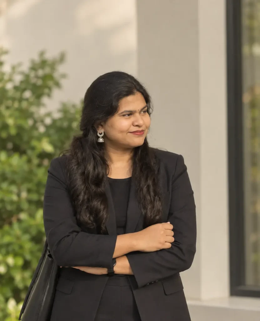 Portrait of a professional Digital Marketing Specialist in Kerala wearing a black blazer with crossed arms in an outdoor office setting web design specialist in kerala